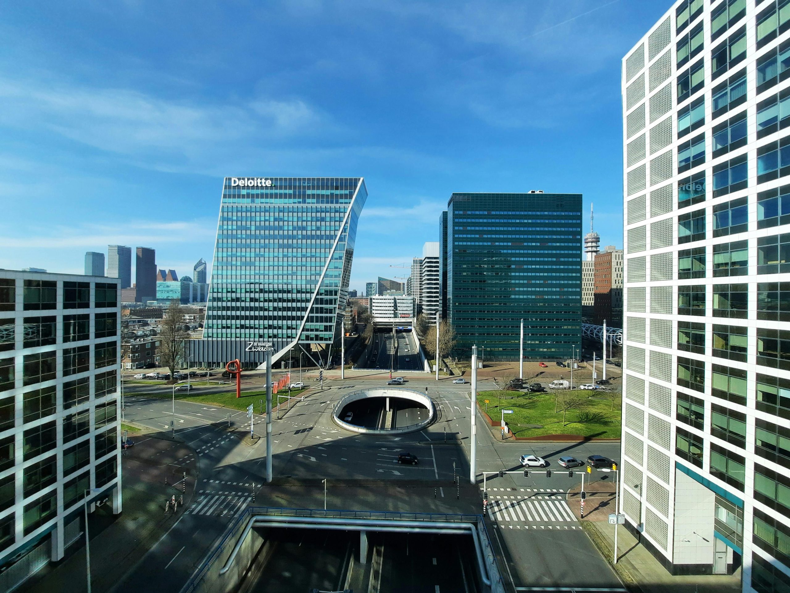 Skyline view of modern office buildings in The Hague, Netherlands, under a clear blue sky.